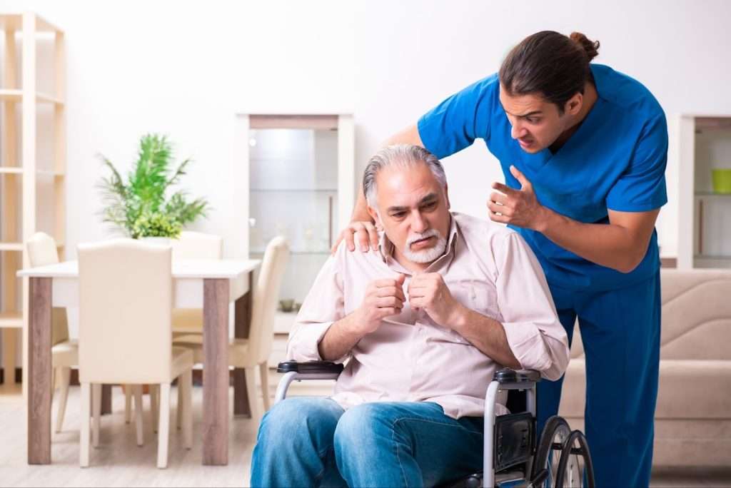 Old man in wheel-chair and young caregiver